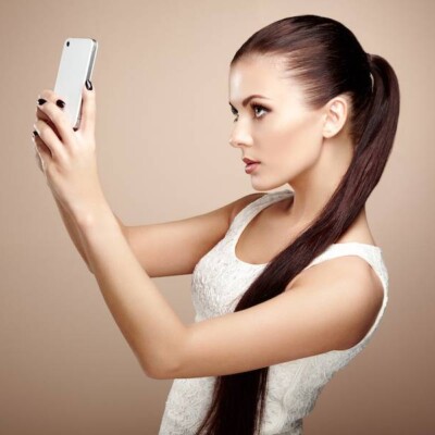 Beautiful young woman taking selfie